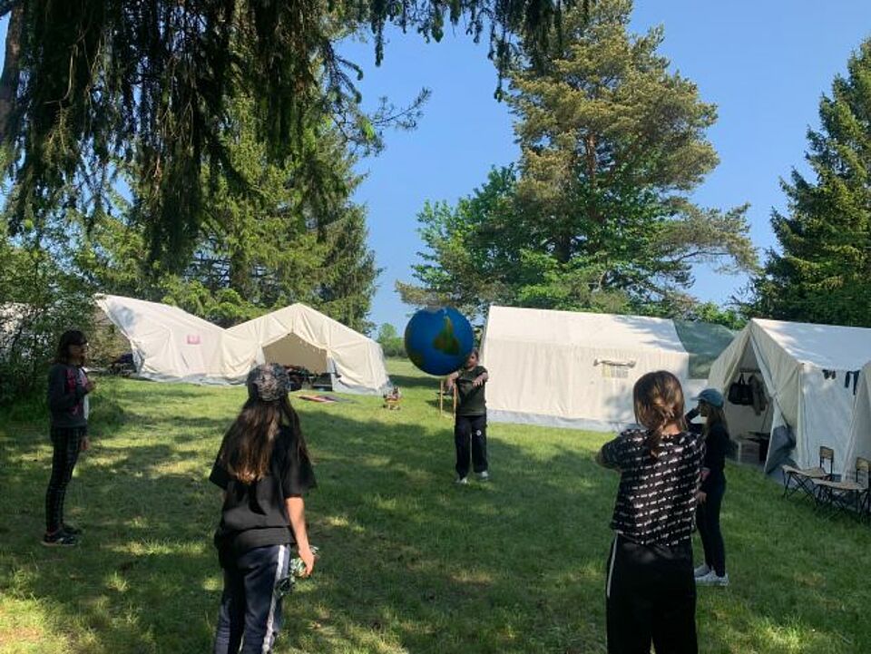 zu sehen ist eine Gruppe vor den Zelten beim Zeltlager 2023
